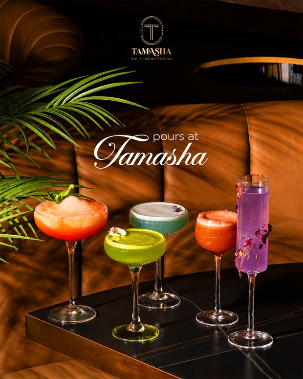 Four signature Tamasha cocktails lined up on a dark table