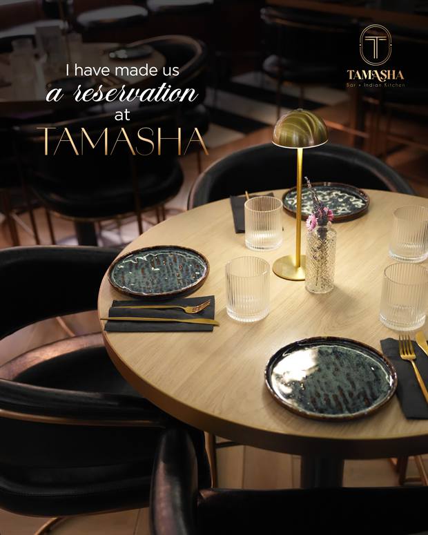 A table set for two under warm golden light at Tamasha